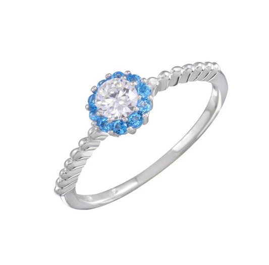 Rhodium plated 925 sterling silver ring with a clear cubic zirconia center gem surrounded by blue gems.