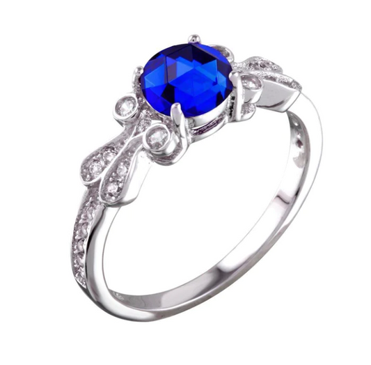 Rhodium plated 925 sterling silver ring with a beautiful dark blue round gem in the center. 