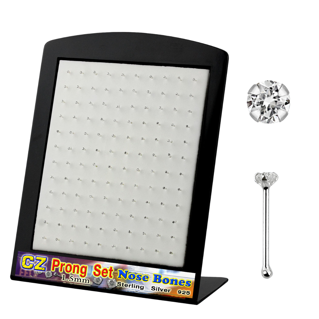 A black L-shaped display stand holding a collection of sterling silver prong-set nose bones. To the right, a detailed close-up shows a clear round CZ gemstone and a straight nose bone post with a small ball end. A colourful label on the base reads "CZ Prong Set Nose Bones 1.5mm Sterling Silver 925