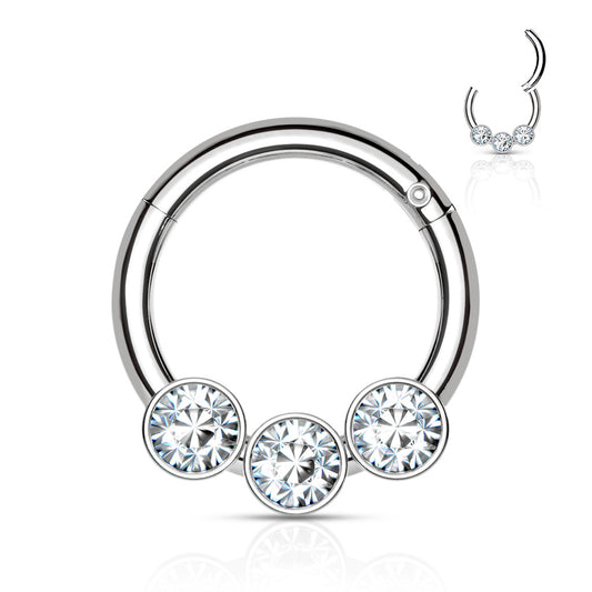 Elegant hinged segment clicker. 316L Surgical steel with 3 clear bezel set gems. The rounded top of this hinged clicker makes it a great piece of jewellery for septum, daith, tragus, or rook piercings. 16 Gauge X 8mm.