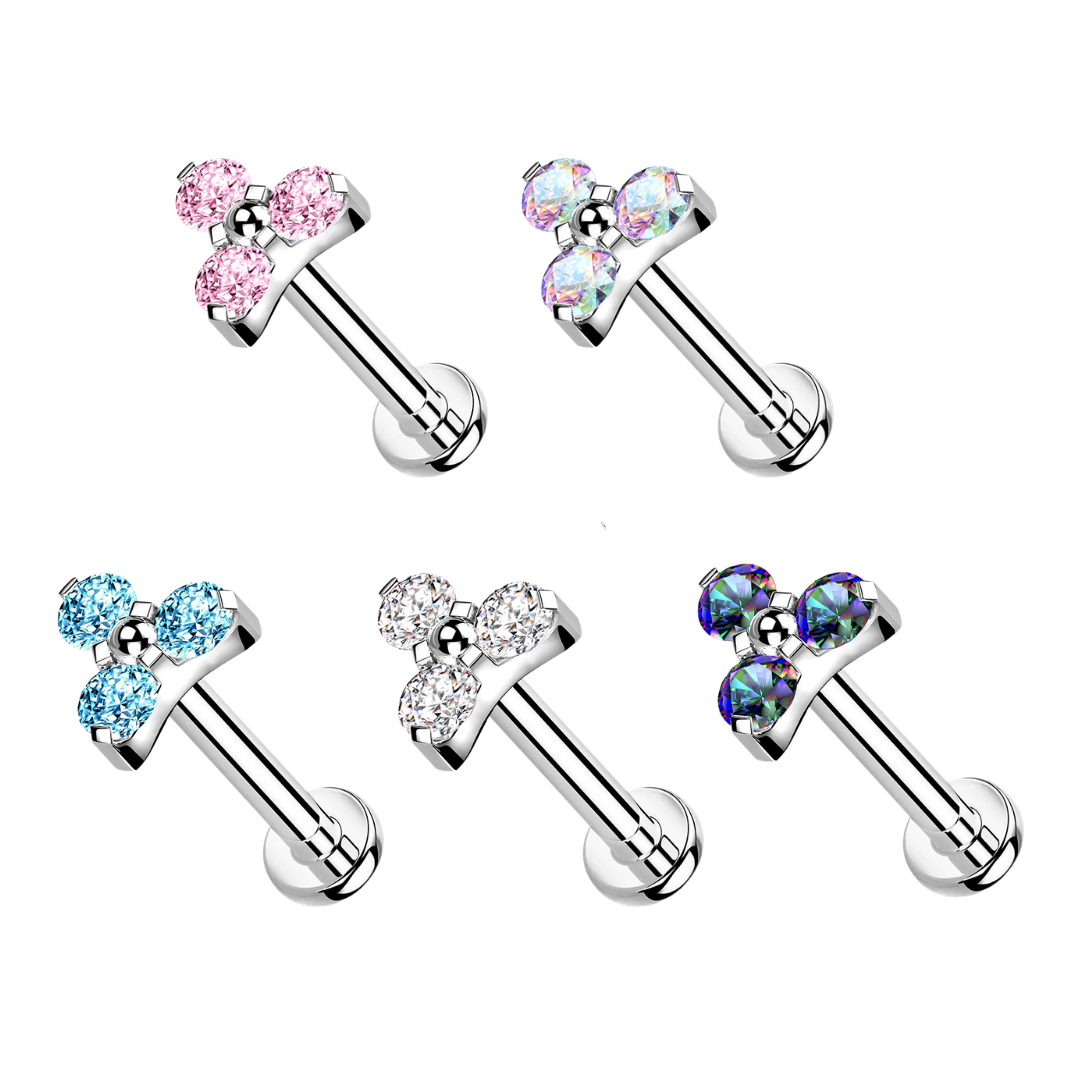 Five internally threaded titanium labret stud piercings with flat backs, each featuring a prong-set three-stone trinity crystal top in pink, iridescent Aurora Borealis, light blue, clear white, and dark blue-purple on a white background.