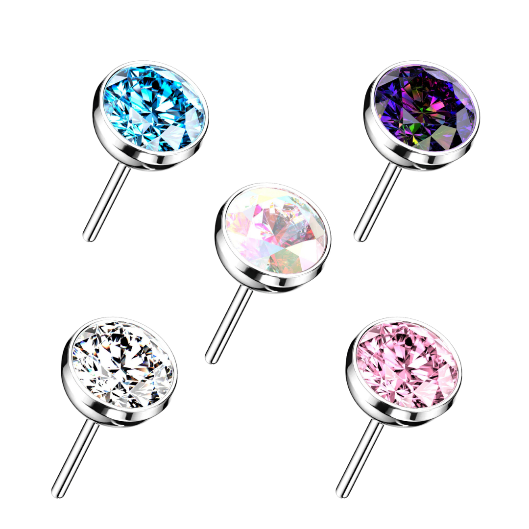 Five titanium  round stud earrings with silver-toned metal settings and faceted gemstones in blue, purple, iridescent pink, clear, and pink, arranged on a plain white background.
