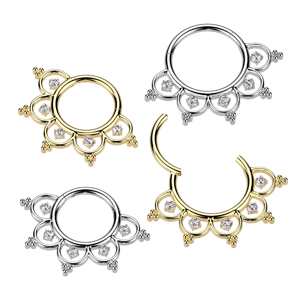 A collection of gold plated and titanium hinged segment ring with ornate filigree design, adorned with clear cubic zirconia gems.