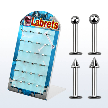 A flat display stand featuring rows of surgical steel ball and spike labret piercing studs.
