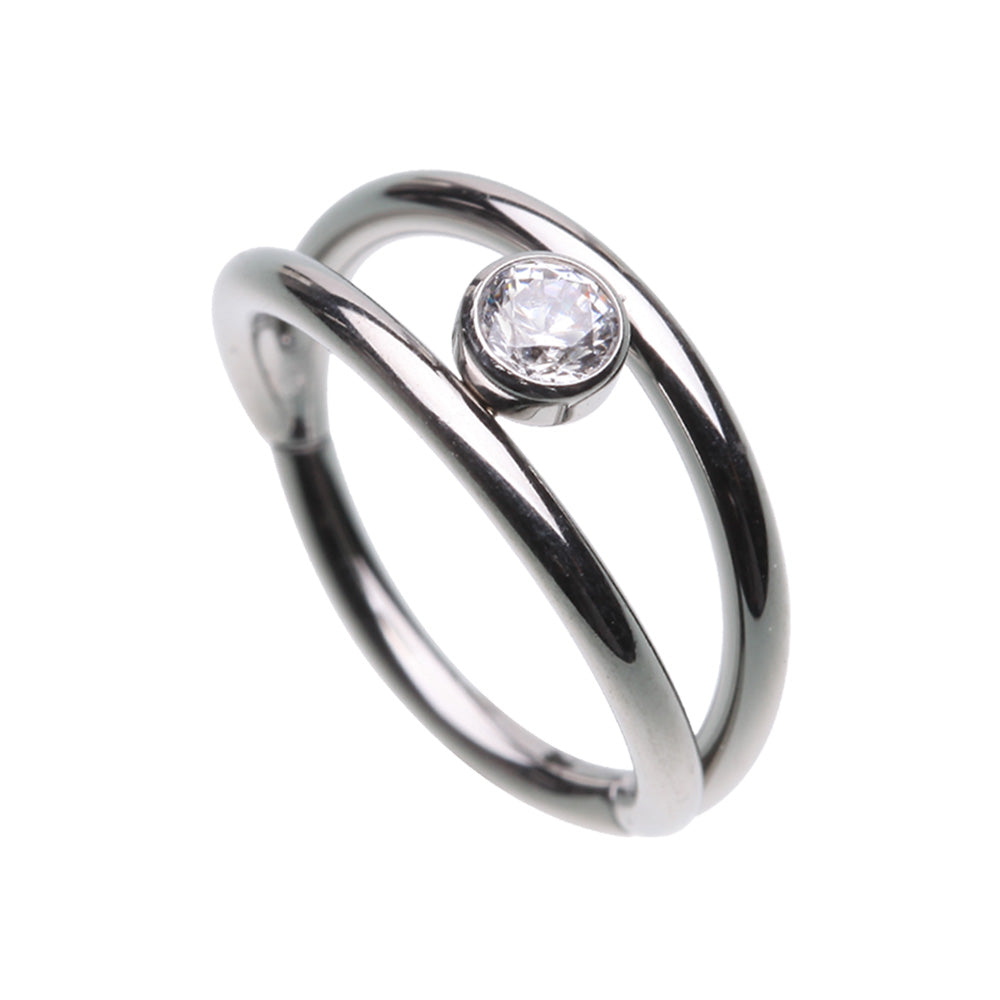 Hinged segment clicker with a double look, featuring two 316L surgical steel hoops with a clear gem in the middle. The rounded top of this hinged clicker makes it a great piece of jewellery for septum, daith, tragus, or rook piercings.