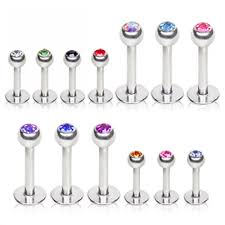 A collection of surgical steel labret studs with assorted colored round gems in various lengths.