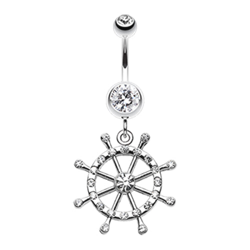 A nautical-themed belly button ring featuring a silver-colored ship's wheel dangle with clear crystals